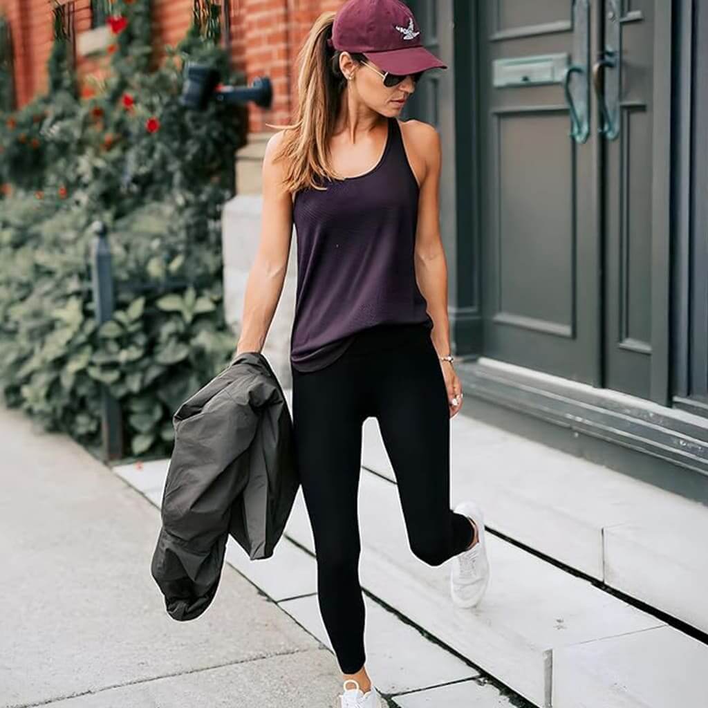 Woman wearing FormFit Leggings and a tank top, showcasing style and practicality for workouts or casual outings.